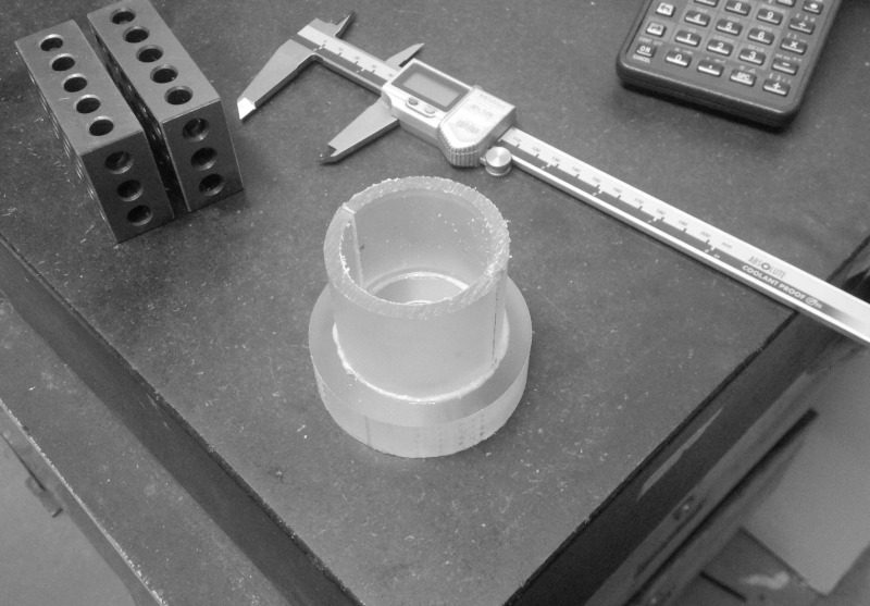Inspection blocks, calipers, and lathe part on granite plate.